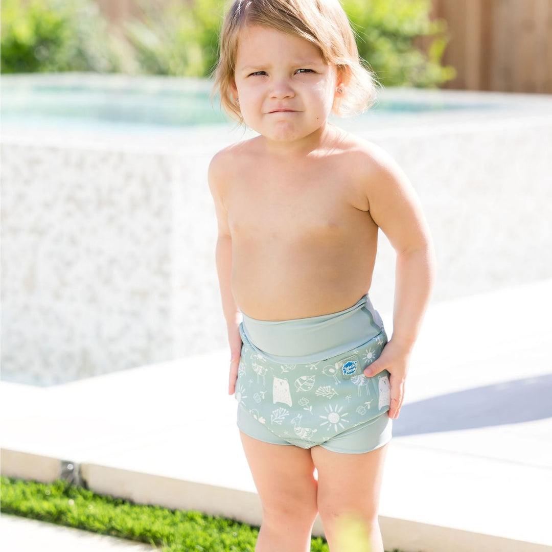 Little one wearing Happy Nappy in greenish blue, featuring animals themed print in white.Front.