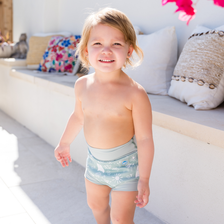 Lifestyle image of little one wearing swim nappy, standing up.