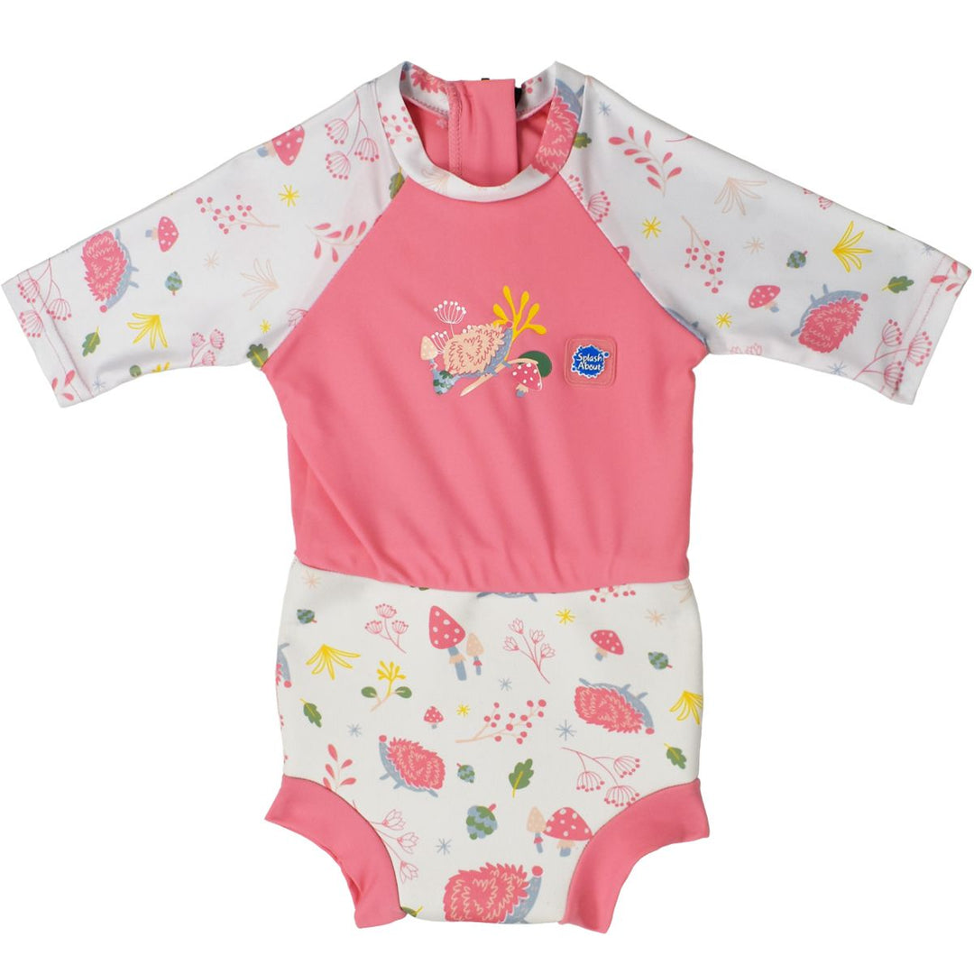 Happy Nappy Sunsuit in pink and forest themed print, including hedgehogs, mushrooms and leaves. Front.