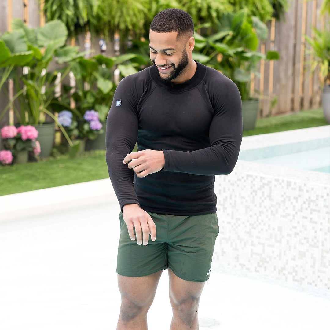 Man wearing green swim shorts for men in green by the pool.