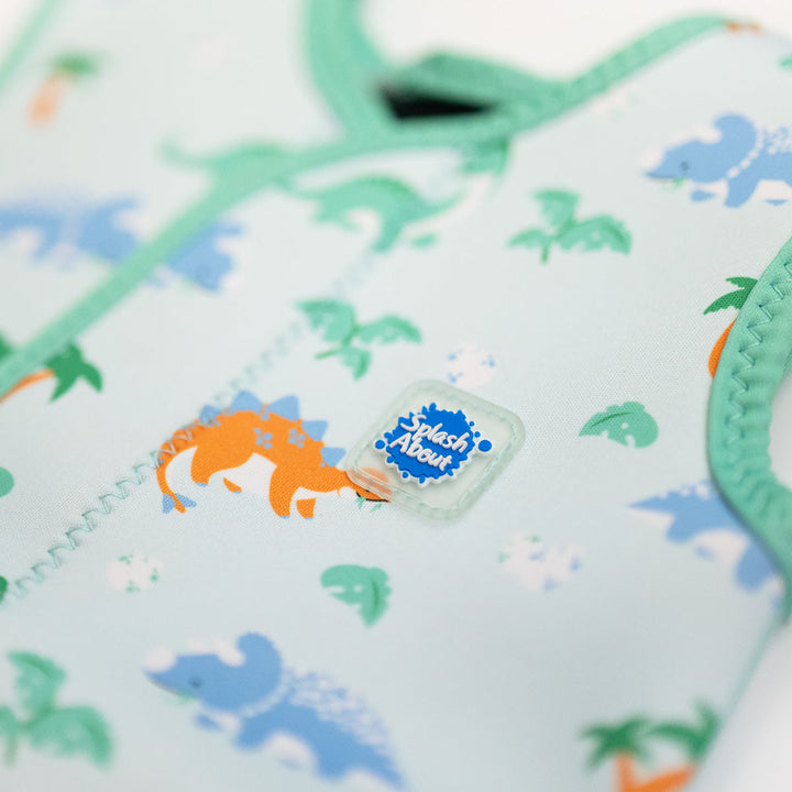 Close up of  neoprene baby wrap wetsuit in mint and dinosaurs themed print.