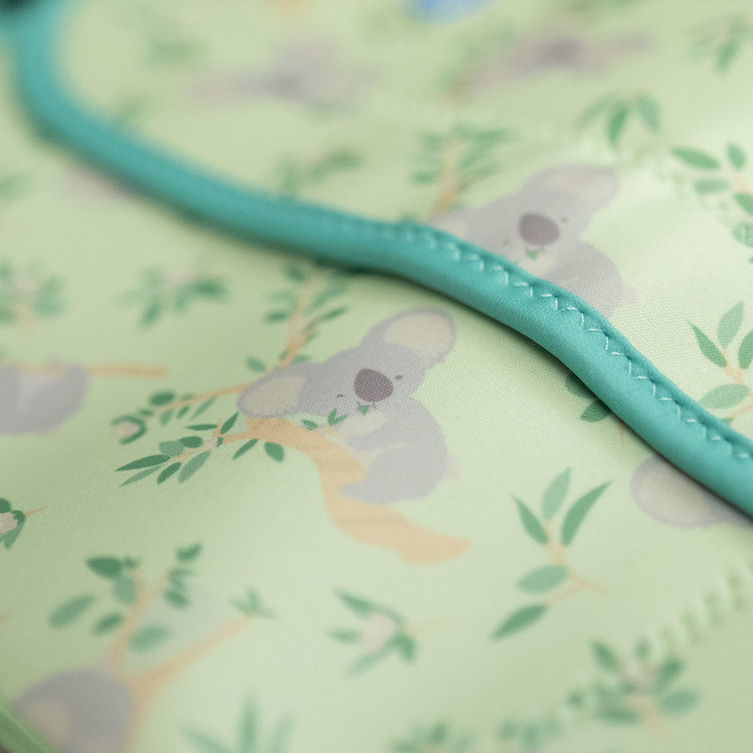 Close up of neoprene baby wrap wetsuit in light green and koalas themed print.