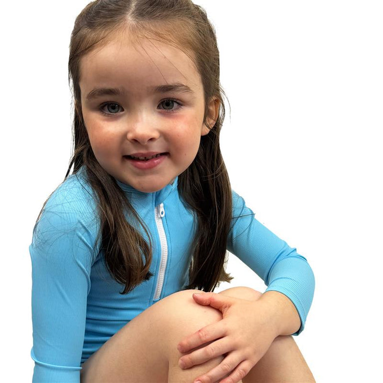 Little one wearing UV protective long sleeve rash top in neon blue.