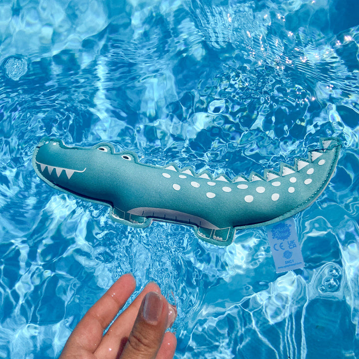 Crocodile themed neoprene toy, floating in the pool