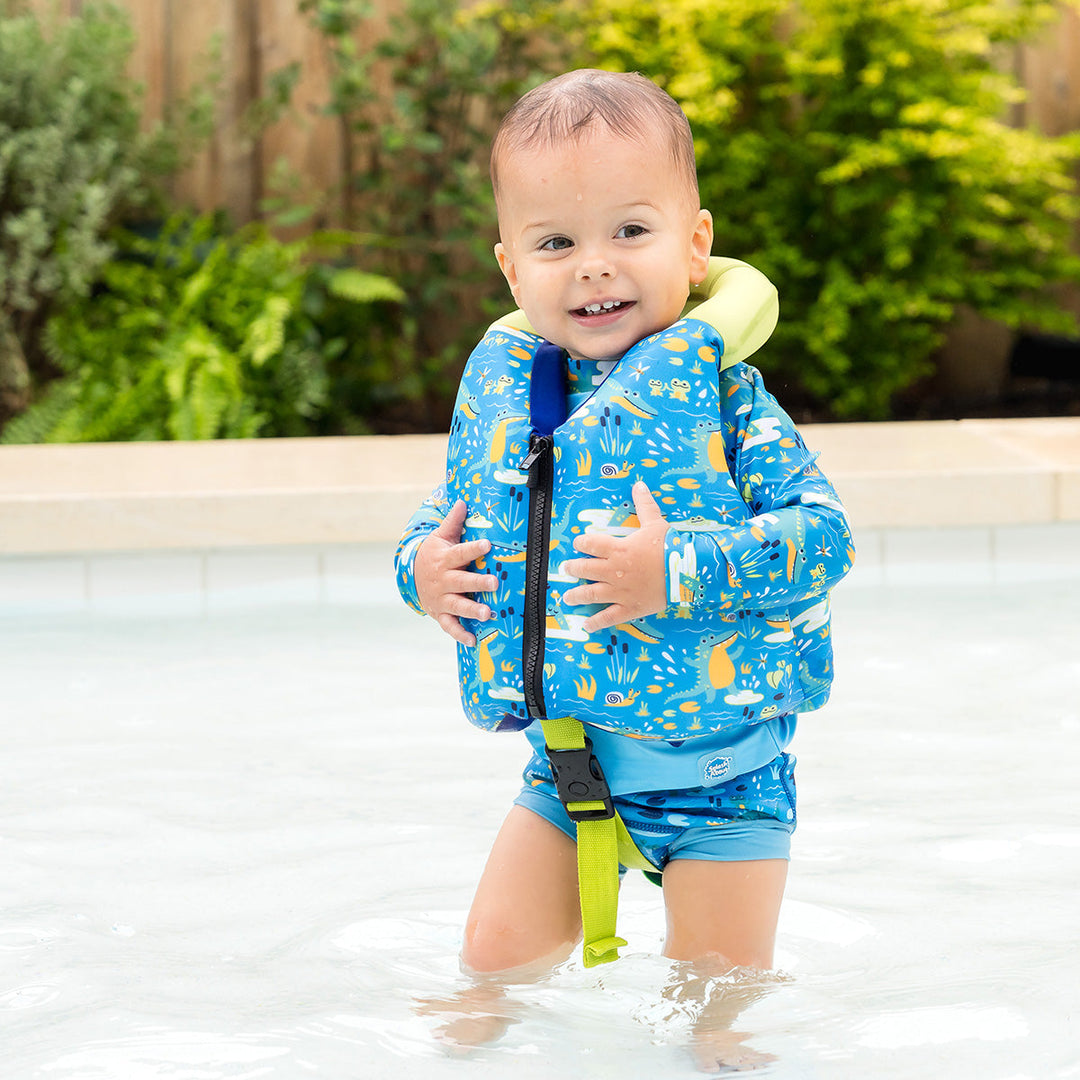 Little one wearing swim vest with crocodile print, front zip and bright trim for kids learn to swim