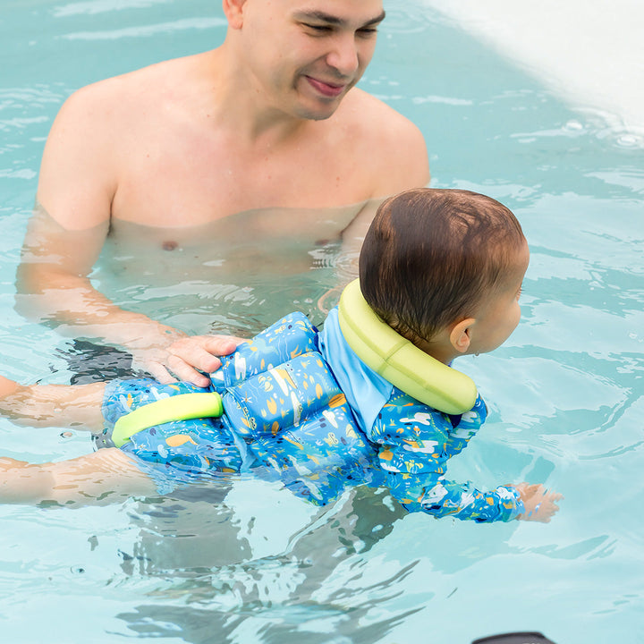 Little one in the pool, wearing swim vest with crocodile print, front zip and bright trim for kids learn to swim