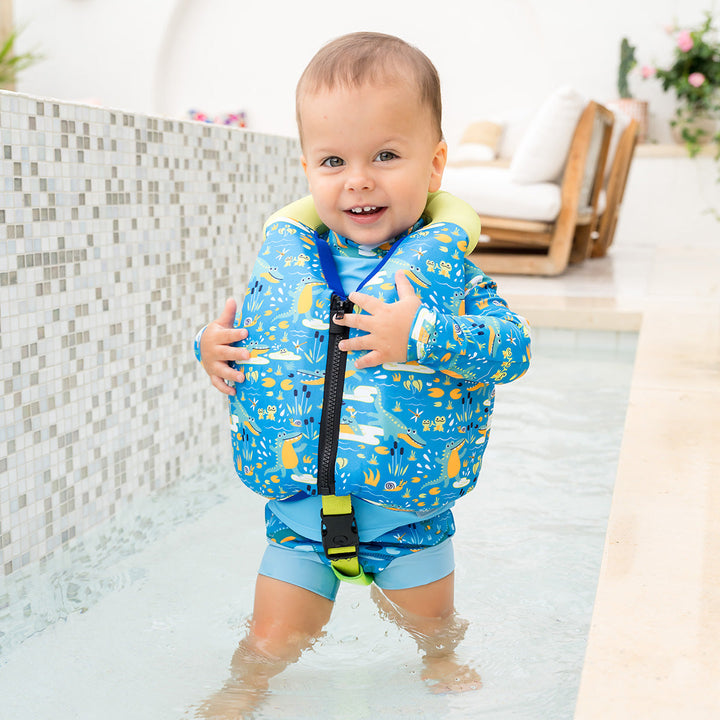 Little one wearing swim vest with crocodile print, front zip and bright trim for kids learn to swim