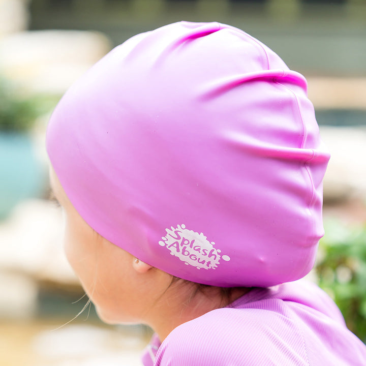 Close-up of kid wearing purple silicone swim cap, back.