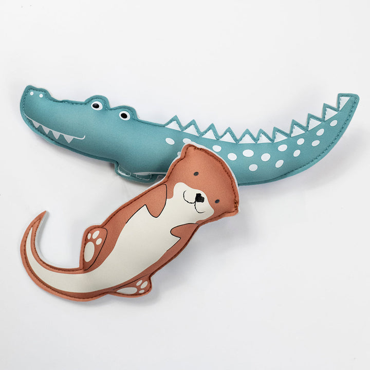 Flat lay image of crocodile and otter themed neoprene toys, front