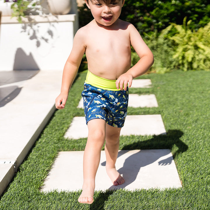 Child wearing neoprene swim shorts in navy and turtles and mantrays themed print.