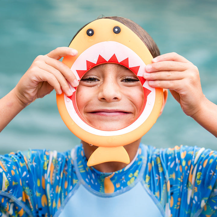 Kid playing with orange shark dive ring
