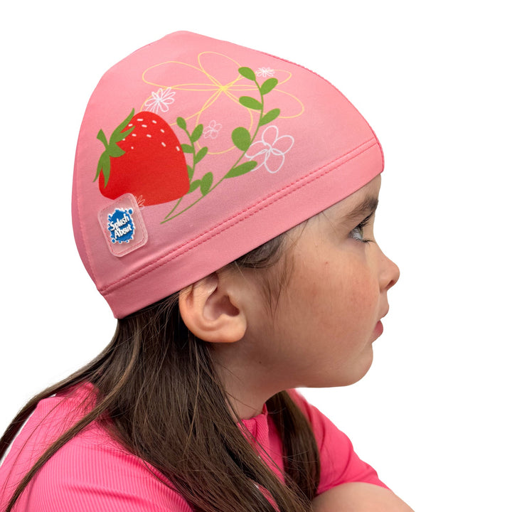 Baby swim hat in pink featuring strawberries themed print.