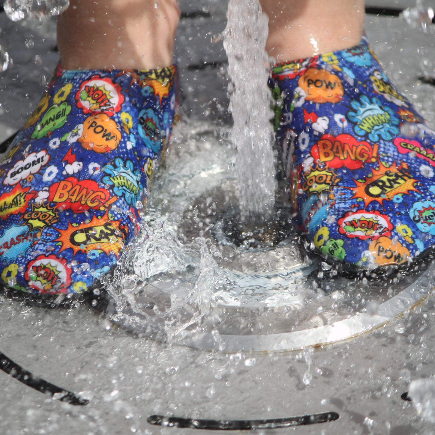 Lifestyle image of kid wearing superhero themed non-slip shoes, in a pool shower.
