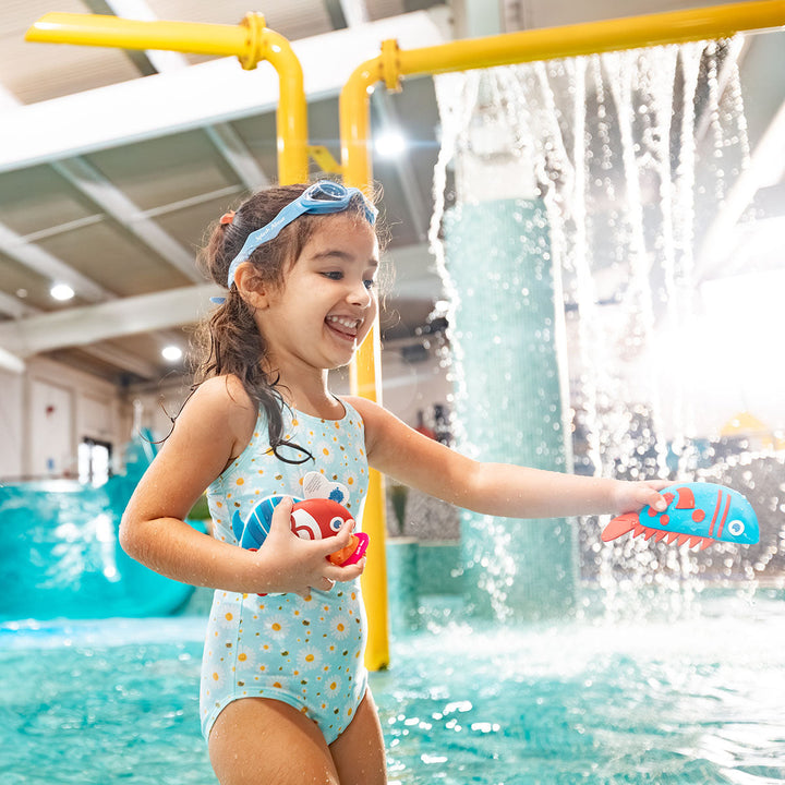 Kid playing with a blue and red silicone fish toy in the pool