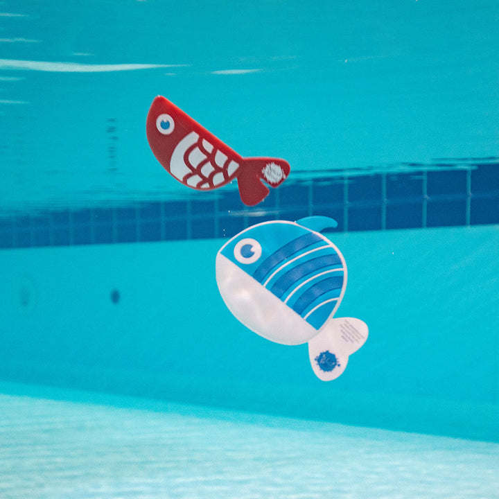 Blue and red silicone fish toy, and a red and white silicone fish toy, in the pool