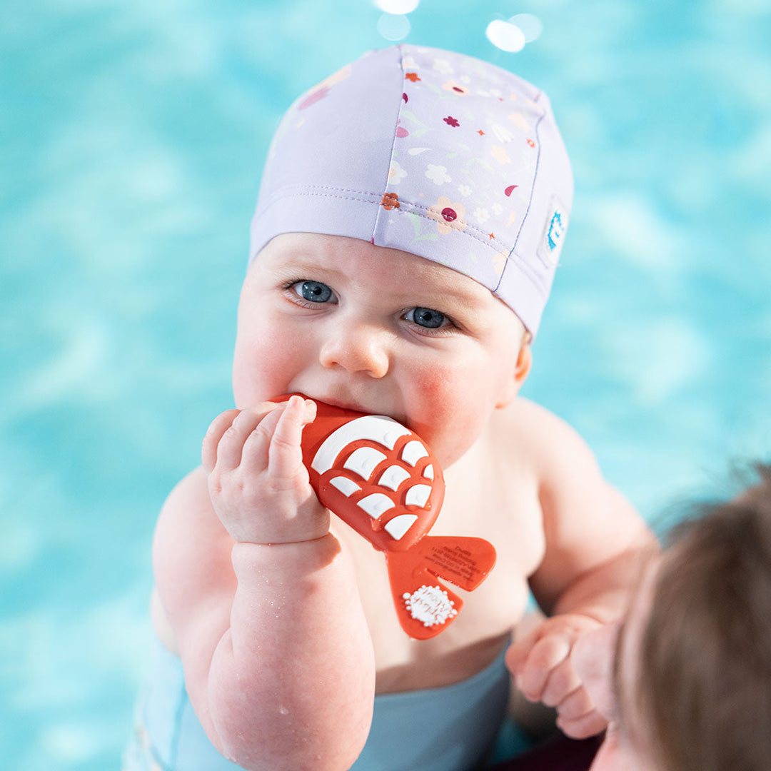 Baby biting red and white silicone fish