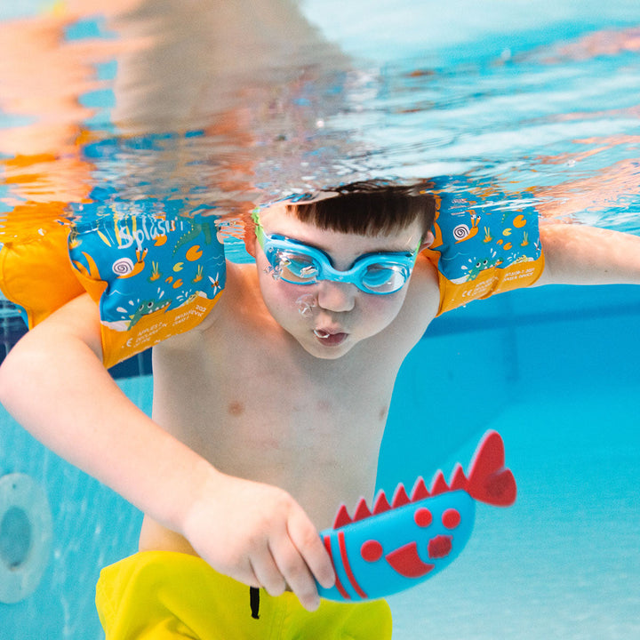 Kid playing with a blue and red silicone fish toy in the pool