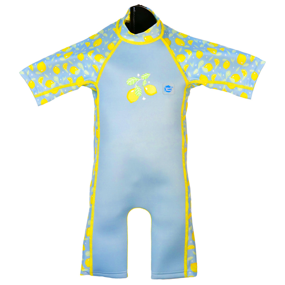 One piece UV sun and sea wetsuit for toddlers in light blue, featuring lemons themed print on sleeves, side panels, neck and chest. Front.