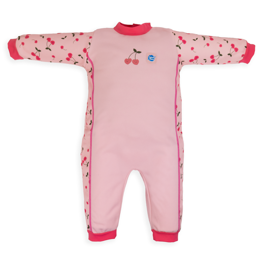 Flat lay image of fleece-lined baby wetsuit in pink with cherries themed print. Front.