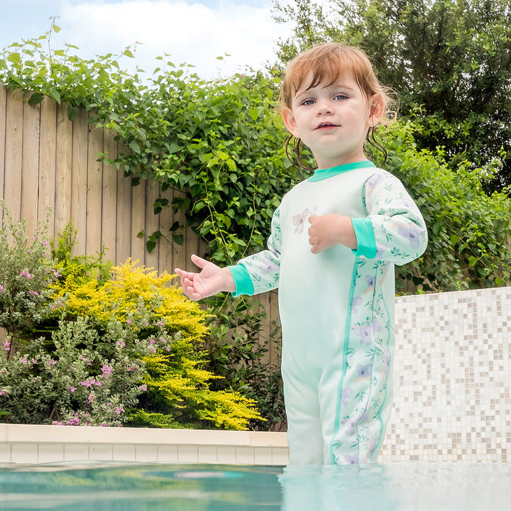 Little one wearing fleece-lined baby wetsuit in light green with mint trims and koalas themed print.