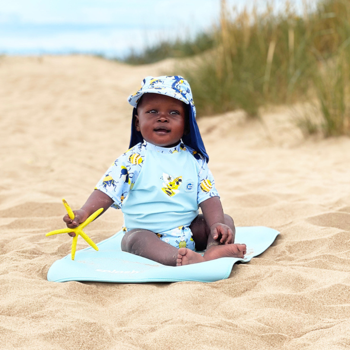 Child on neoprene mat at the beach