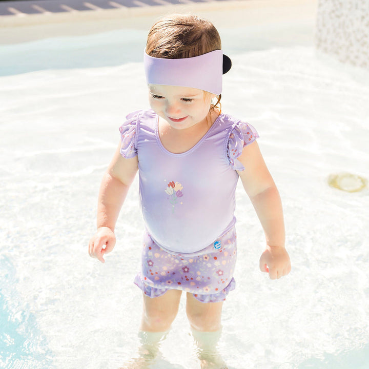 Little one wearing swim ear band in lilac, back