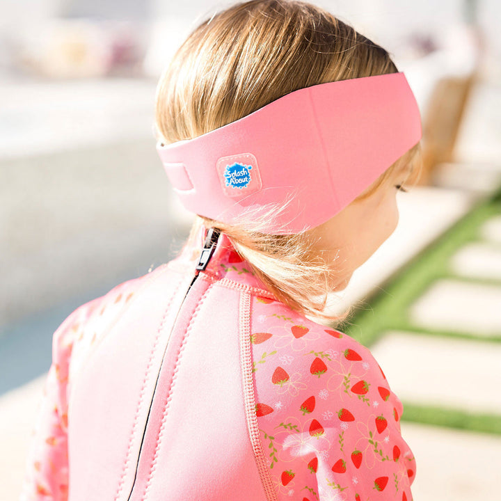 Little one wearing swim ear band in pink, back