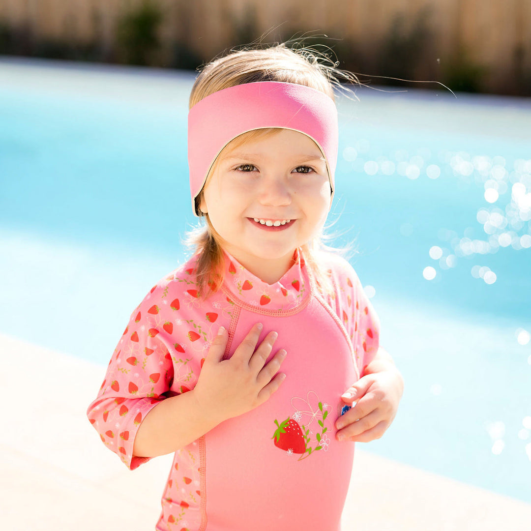 Little one wearing swim ear band in pink, front