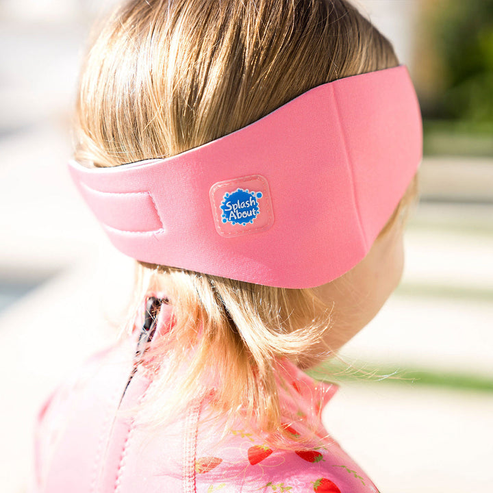 Little one wearing swim ear band in pink, back