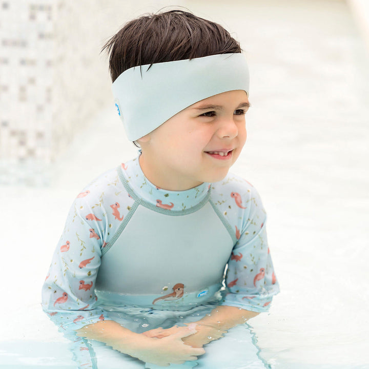 Little one wearing swim ear band in pistachio, side