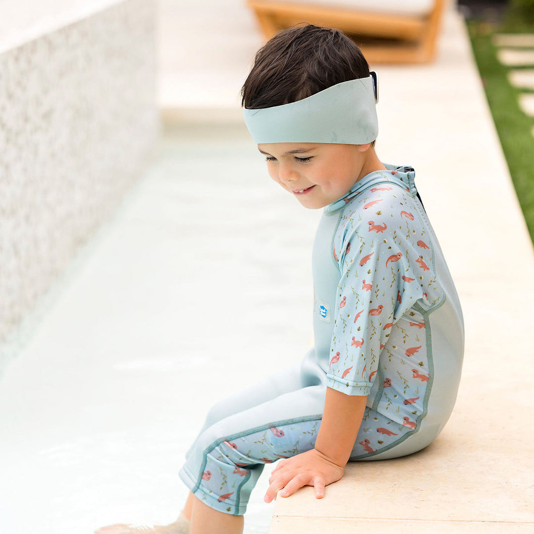 Little one wearing swim ear band in pistachio, side
