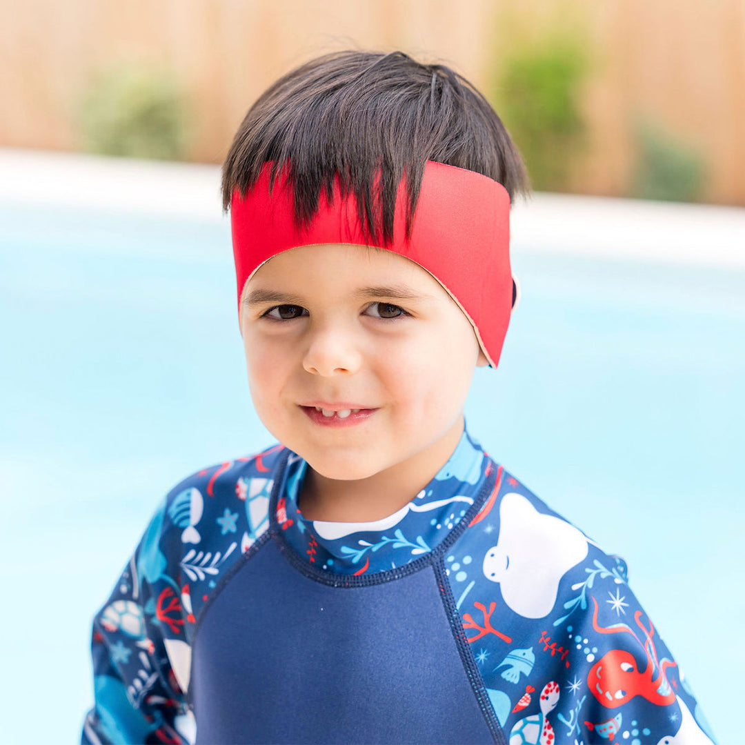 Little one wearing swim ear band in red, front