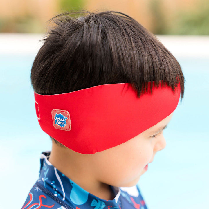 Little one wearing swim ear band in red, side