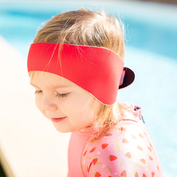 Little one wearing swim ear band in red, side