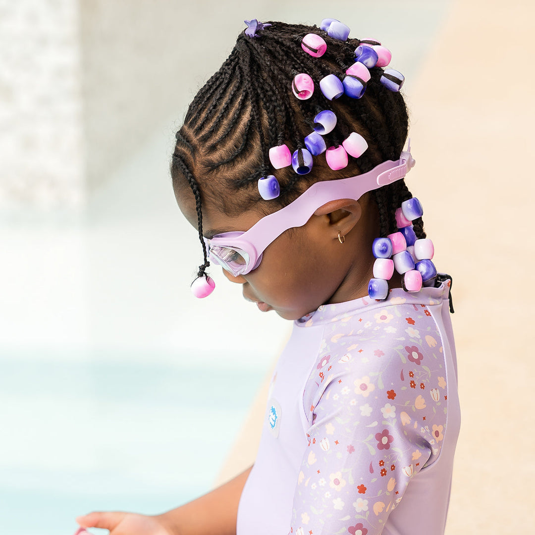 Little one wearing lilac goggles poolside