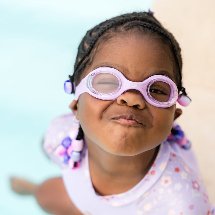 Little one wearing lilac goggles poolside
