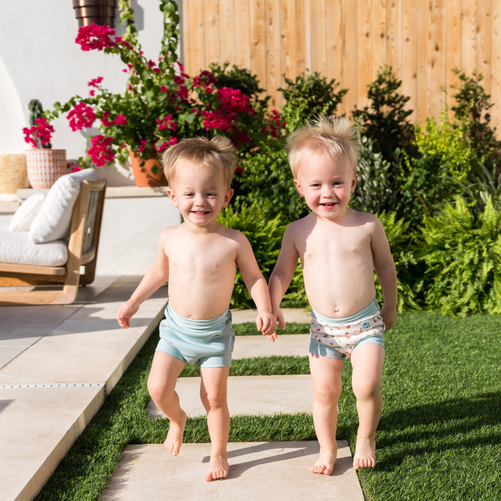 Children wearing reusable swim nappy in pistachio. Front