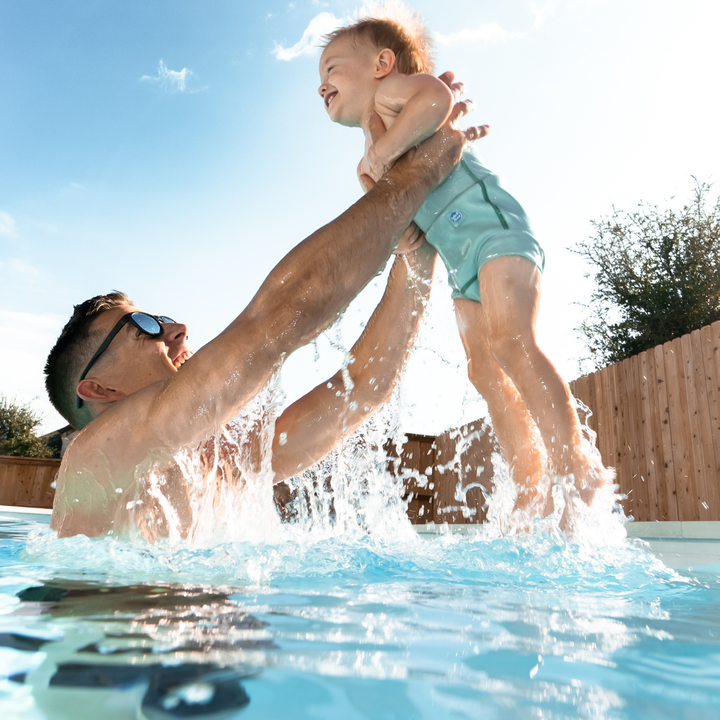 Dad and little one in the pool.