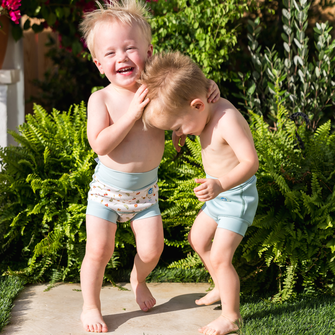 Children wearing reusable swim nappy in pistachio. Front