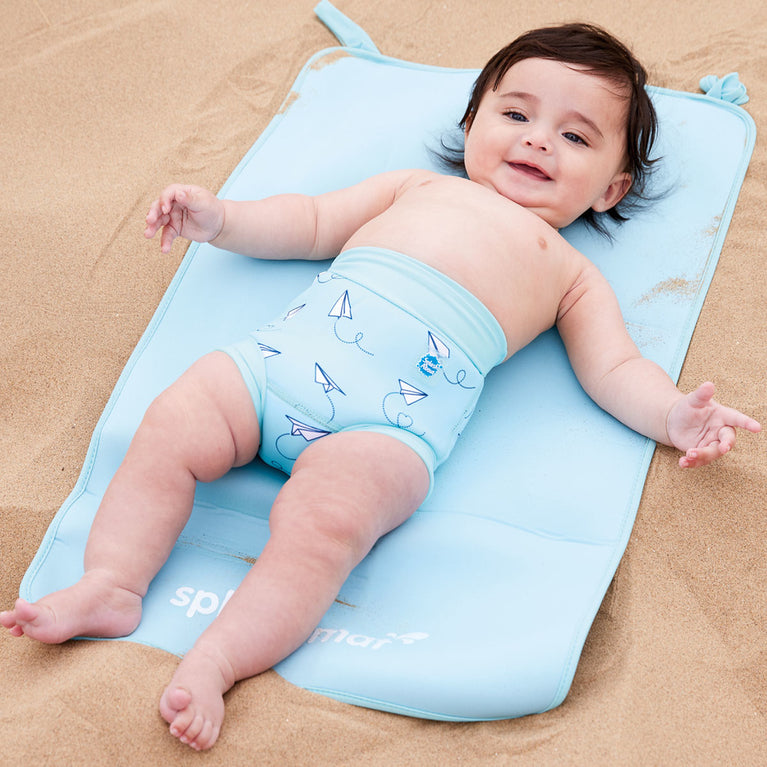 Child on neoprene mat at the beach