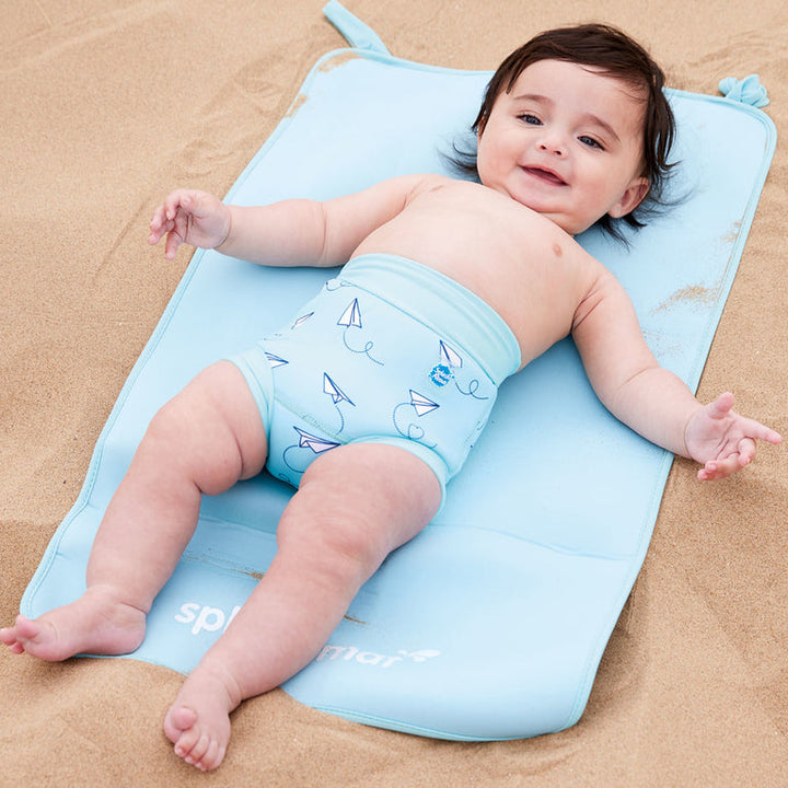 Child on neoprene mat at the beach