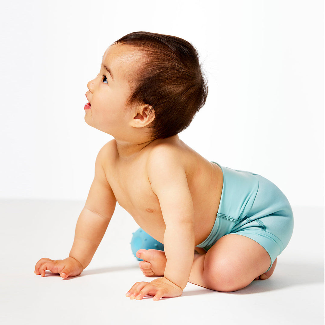 Little one wearing neoprene swim nappy, in pistachio colour.