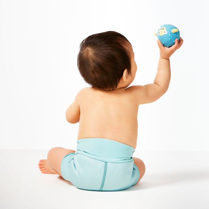 Little one wearing neoprene swim nappy, in pistachio colour.