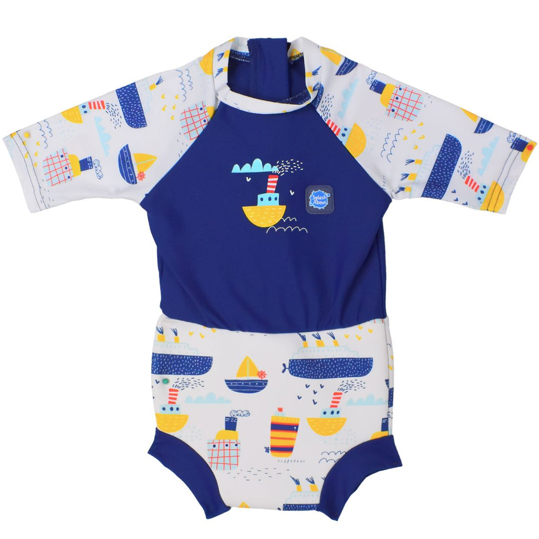 Happy Nappy Sunsuit in white and navy, and boats themed print. Front.