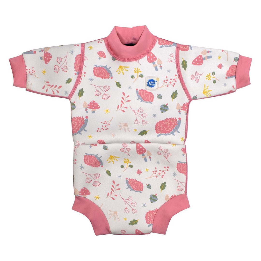 Baby wetsuit with built in swim nappy in white with pink trims and forest themed print, including hedgehogs, mushrooms and leaves. Front.