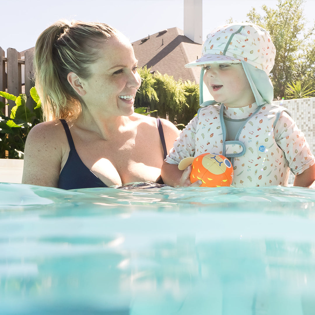 Little one wearing legionnaire style sun hat in light blue and white, with acorns and leaves themed print panel. They are also wearing matching swim vest.