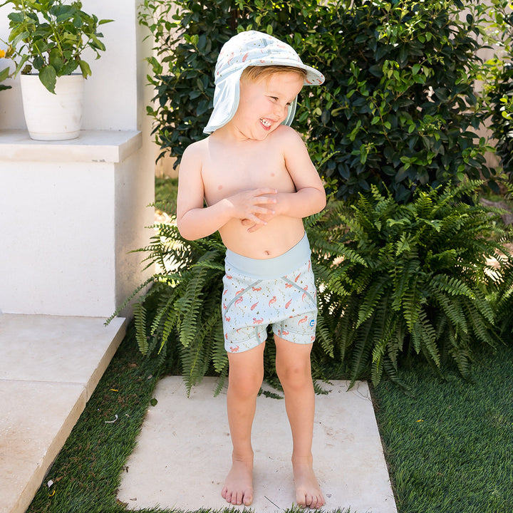 Child wearing neoprene swim shorts in blue with otters themed print.