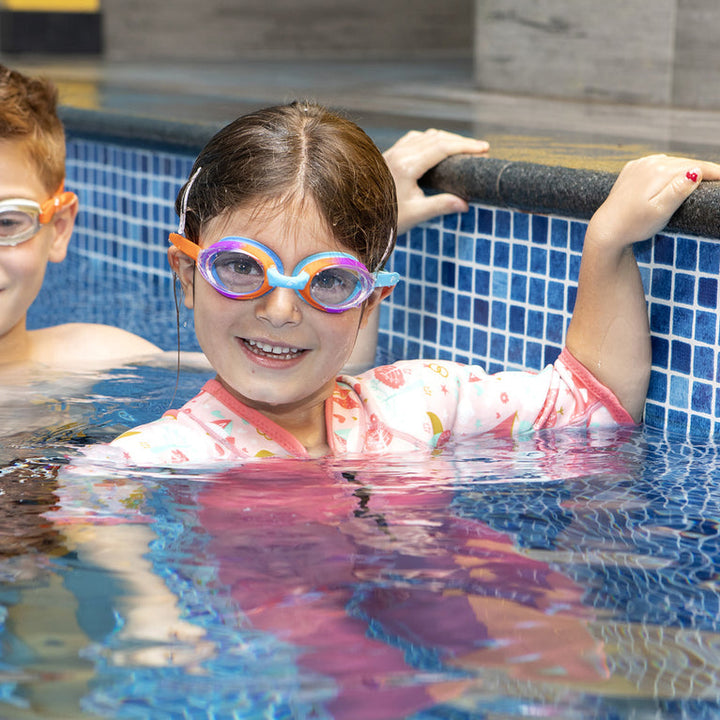 Little one wearing colourful goggles in the pool