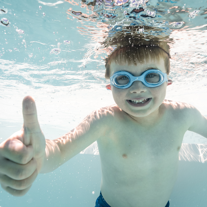 Little one wearing blue goggles underwater