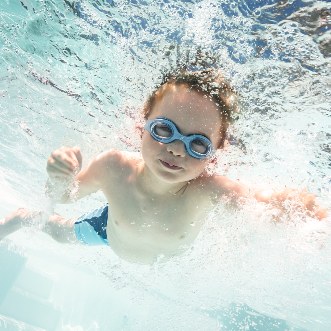 Little one wearing blue goggles underwater